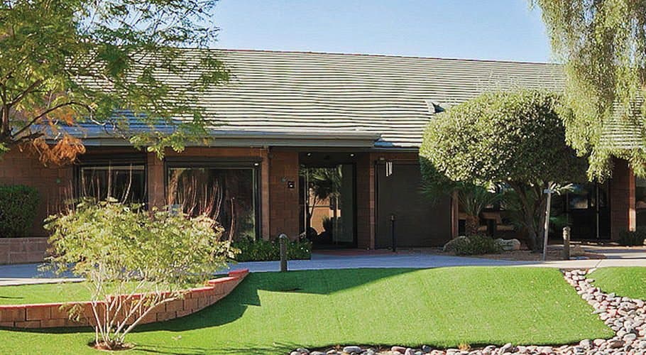 Ranch style brick building with trees and rock landscaping arizona
