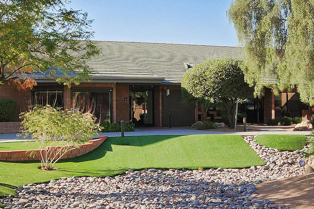 Ranch style brick building with trees and rock landscaping vogue recovery center arizona facility
