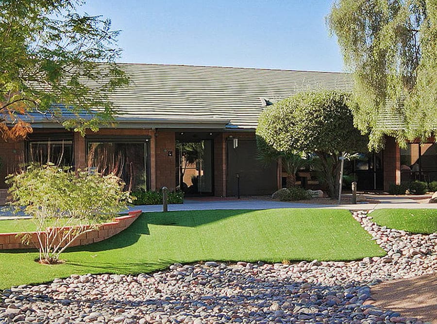 Ranch style brick building with trees and rock landscaping vogue recovery center arizona facility