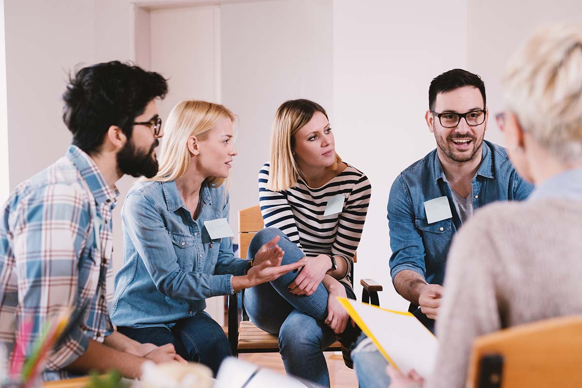 people in therapy circle discussing individual vs group therapy