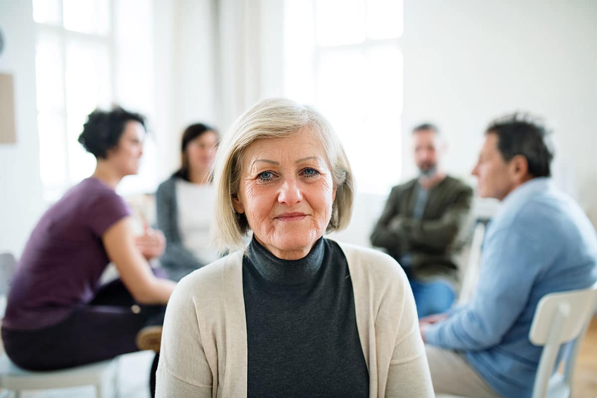 older woman with therapy circle in background as part of best drug rehab programs